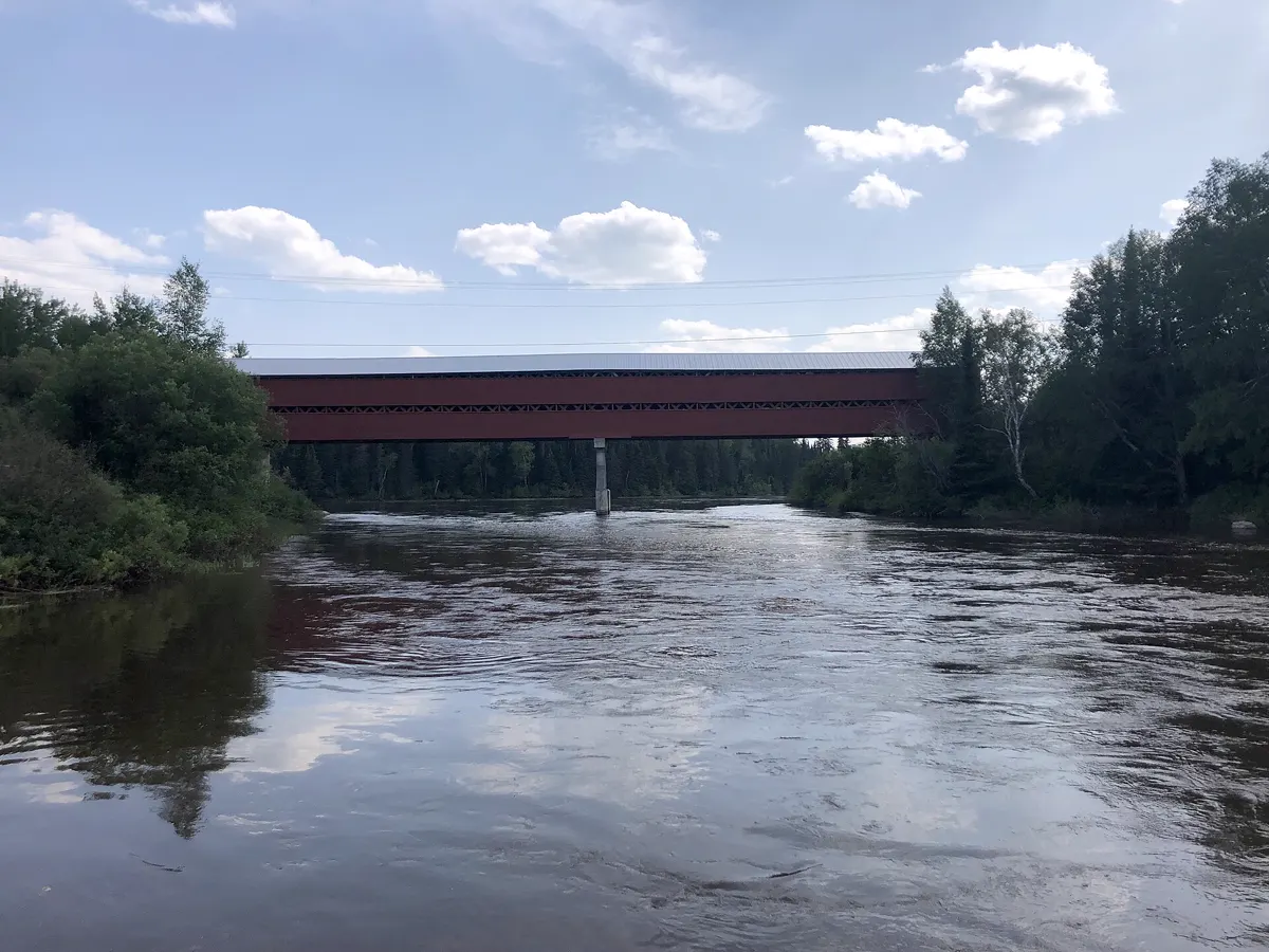 Pont couvert rouge au-dessus de la rivière Harricana, en été